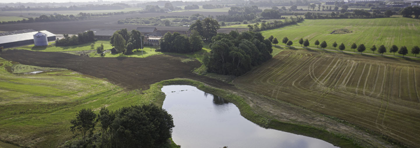 Luftfoto af landbrugsjord med minivådområde