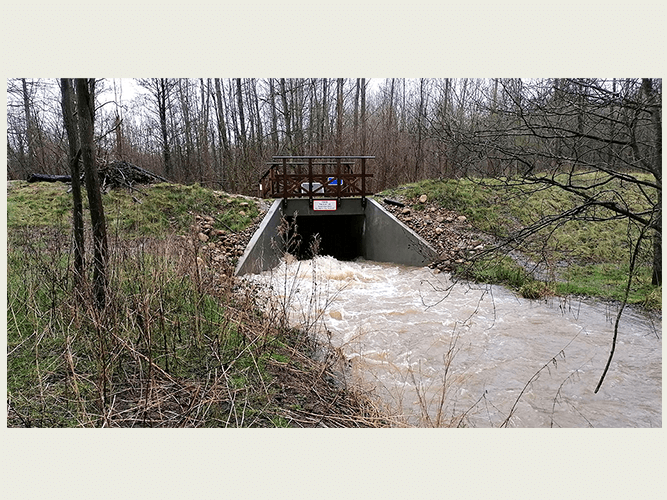 Rathlousdaldæmningen i fuld aktion. Her ses hvordan vandet presses gennem det begrænsede gennemstrømningsprofil på nedstrøms side af løsningen