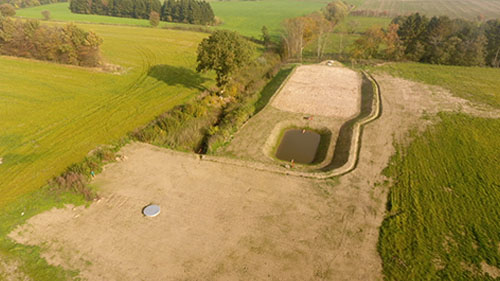 Dronefoto af minivådområde med træflis
