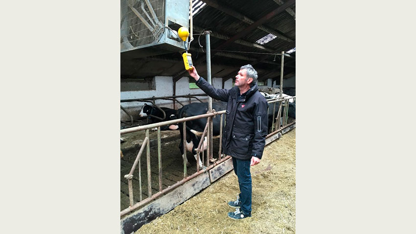 Mand måler strøm i stald