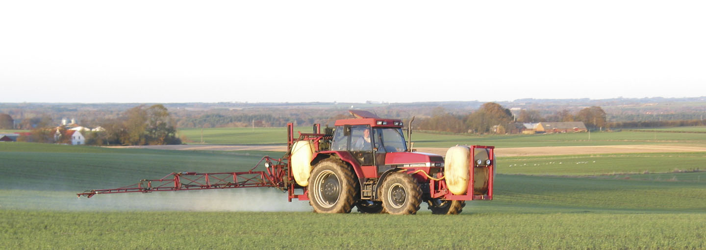 Traktor der sprøjter på marken